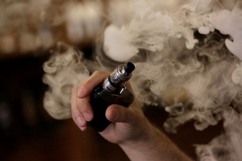 &copy; Reuters. FILE PHOTO: A man holds an electronic cigarette as he vapes at a Vape Shop in Monterrey, Mexico February 1, 2019. Picture taken February 1, 2019. FREUTERS/Daniel Becerril/File photo