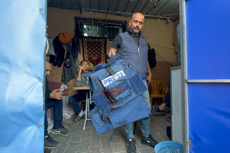 &copy; Reuters. Homem segura colete de proteção pertencente a Wael Al-Dahdouh, jornalista da Al Jazeera, em Khan Younis, no sul da Faixa de Gaza
15/12/2023 REUTERS/Bassam Masoud