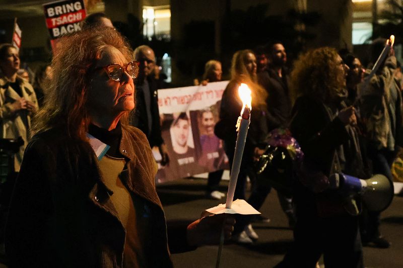 &copy; Reuters. Una mujer sostiene una vela mientras la gente protesta tras el anuncio del ejército de Israel de que habían matado por error a tres rehenes israelíes retenidos en Gaza por el grupo islamista palestino Hamás, en una manifestación en Tel Aviv, Israel, 