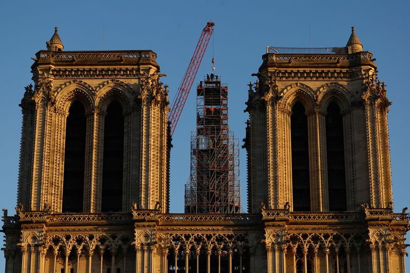 &copy; Reuters. A crane raises the new rooster to install it at the top of the spire of the Notre-Dame de Paris Cathedral, which was ravaged by a fire in 2019 that sent its spire crumbling down, as restoration works continue in Paris, France, December 16, 2023. REUTERS/C