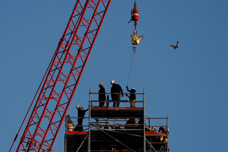 © Reuters. A crane raises the new rooster to install it at the top of the spire of the Notre-Dame de Paris Cathedral, which was ravaged by a fire in 2019 that sent its spire crumbling down, as restoration works continue in Paris, France, December 16, 2023. REUTERS/Christian Hartmann