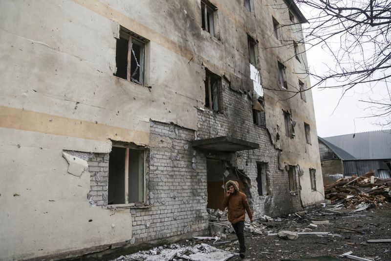 © Reuters. رجل يسير بجانب مبنى متضرر بفعل مسيرة روسية في منطقة أوديسا بأوكرانيا يوم 14 ديسمبر كانون الأول 2023 في صورة لرويترز.