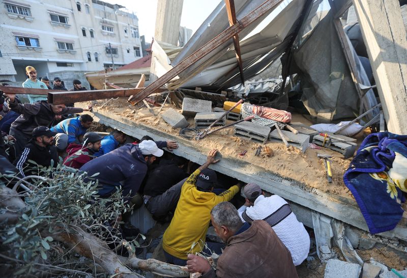 &copy; Reuters. فلسطينيون يتفقدون موقع منزل تعرض لقصف إسرائيلي في مدينة رفح بجنوب قطاع غزة يوم الأحد. تصوير: إبراهيم أبو مصطفى - رويترز.