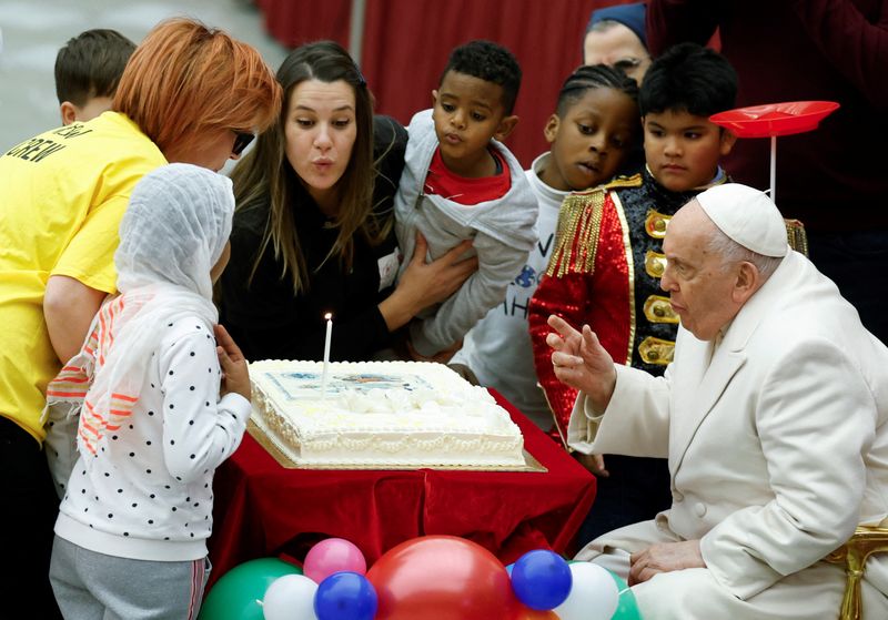 &copy; Reuters. Pope Francis blows a candle on his cake for his 87th birthday, as he meets with a group of sick children from the "Santa Marta" Paediatric Dispensary at the Vatican, December 17, 2023. REUTERS/Remo Casilli