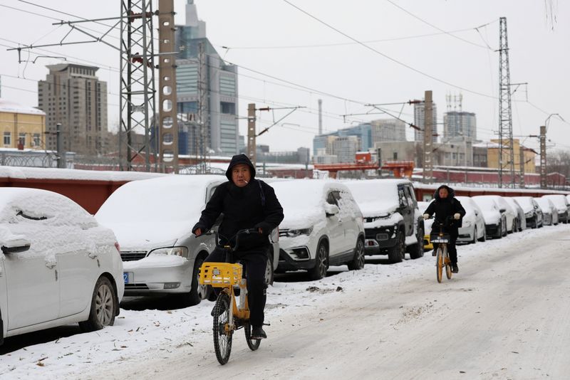&copy; Reuters. شخصان يقودان دراجة في طريق تغطيه الثلوج في بكين يوم 15 ديسمبر كانون الأول 2023. تصوير: تينغ شو وانغ - رويترز.