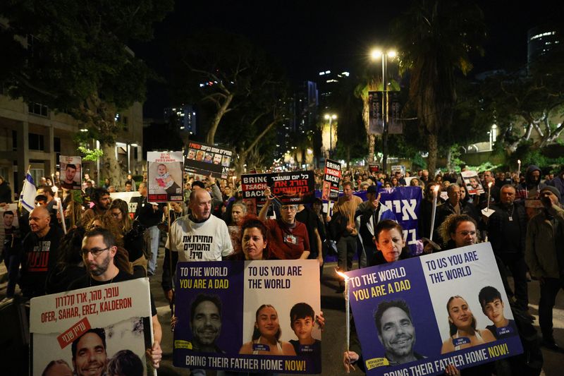 © Reuters. FILE PHOTO: People hold signs as they protest following an announcement by Israel's military that they had mistakenly killed three Israeli hostages being held in Gaza by Palestinian Islamist group Hamas, at a demonstration in Tel Aviv, Israel, December 15, 2023. REUTERS/Violeta Santos Moura/File Photo