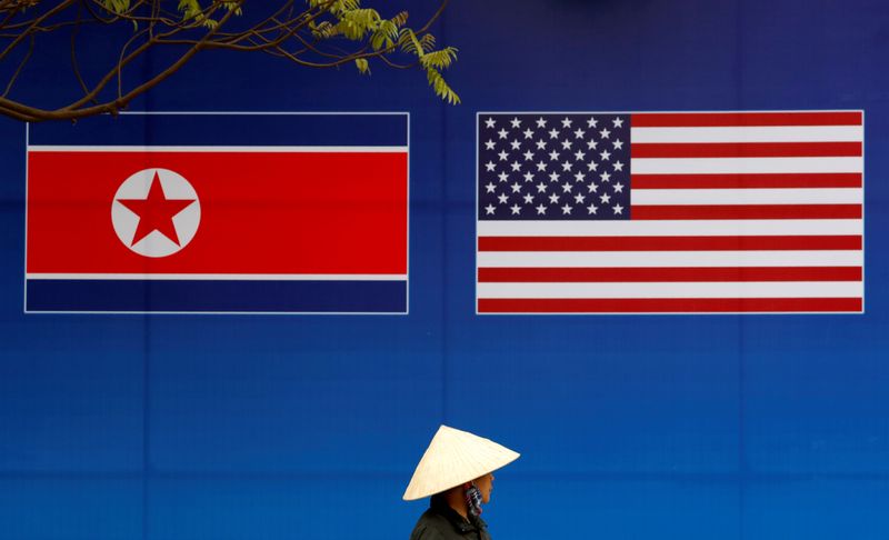 &copy; Reuters. شخص يسير أمام لوحة إعلانية عليها علمي كوريا الشمالية والولايات المتحدة في هانوي بفيتنام. صورة من أرشيف رويترز.
