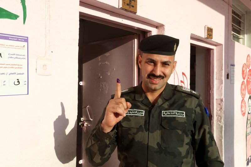 &copy; Reuters. رجل شرطة عراقي يظهر إصبعه المخضب بالحبر لوسائل الإعلام بعد التصويت خلال يوم اقتراع خالص في انتخابات مجالس المحافظات ببغداد يوم 16 ديسمبر كان