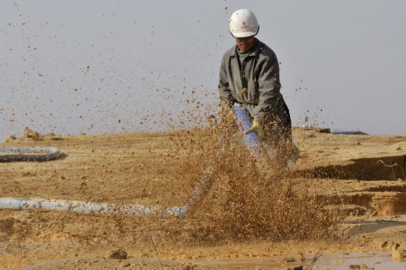 &copy; Reuters. 中国工業情報省は１５日、今年第３弾のレアアース（希土類）の採掘生産枠を１万５０００トンにすると発表した。写真はレアアースの鉱山で水を撒く労働者。中国・江西省で２０１０年撮
