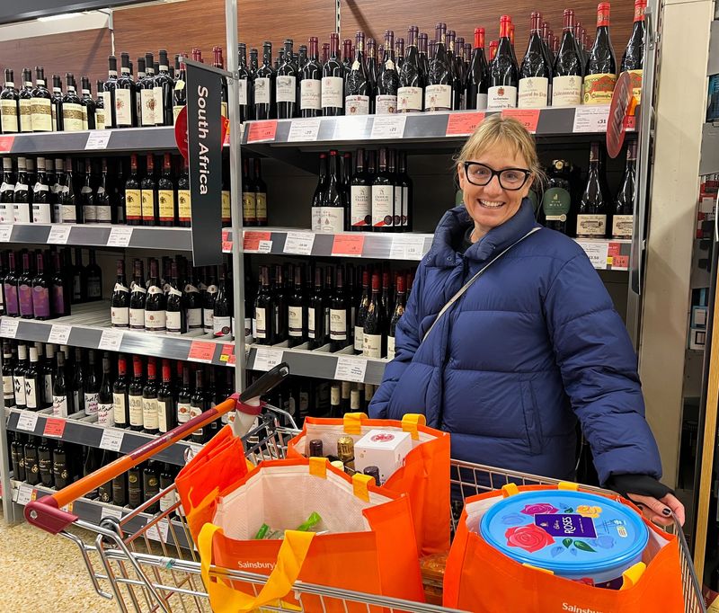 © Reuters. Robyn Asher poses for a picture with her shopping trolley in a wine aisle of a Sainsbury's supermarket in East Dulwich, London, Britain, December 8, 2023. REUTERS/Helen Reid