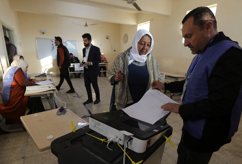 © Reuters. شخص يساعد امرأة في مركز اقتراع أثناء الإدلاء بصوتها في انتخابات مجالس المحافظات في كركوك بالعراق يوم الاثنين. تصوير: أكو رشيد - رويترز.