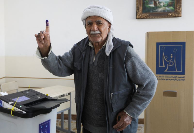 &copy; Reuters. Un homme montre son doigt tatoué après avoir voté lors des élections au conseil provincial irakien, dans un bureau de vote à Kirkouk, en Irak. /Photo prise le 18 décembre 2023/REUTERS/Ako Rasheed