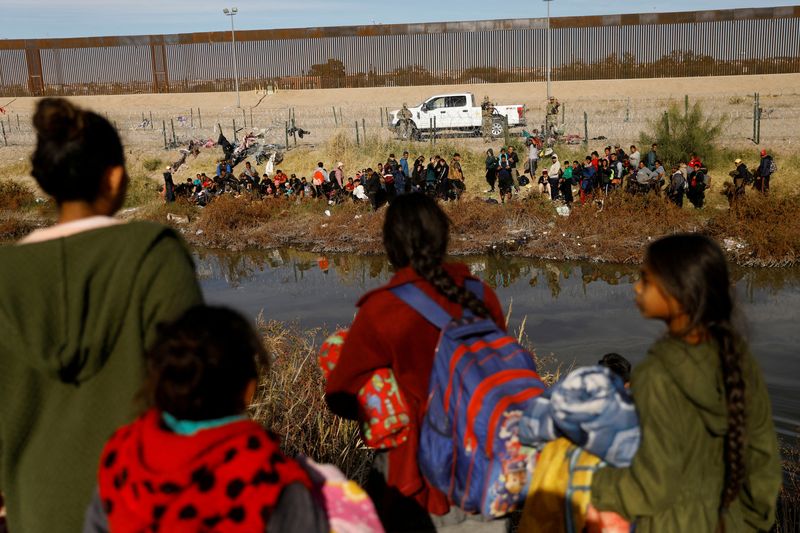 &copy; Reuters. FOTO DE ARCHIVO: Migrantes que buscan asilo en Estados Unidos se reúnen a orillas del río Bravo, mientras la Guardia Nacional de Texas bloquea el cruce en la frontera entre Estados Unidos y México, visto desde Ciudad Juárez, México, 5 de diciembre de