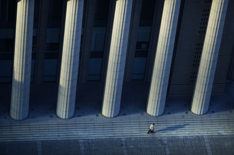 &copy; Reuters. A man walks along an area of the Pudong financial district in Shanghai, November 26, 2014. REUTERS/Carlos Barria/file photo