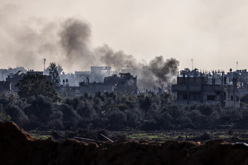 &copy; Reuters. دخان يتصاعد من مباني مدمرة بقطاع غزة يوم 15 ديسمبر كانون الأول 2023. تصوير: عامير كوهين - رويترز.