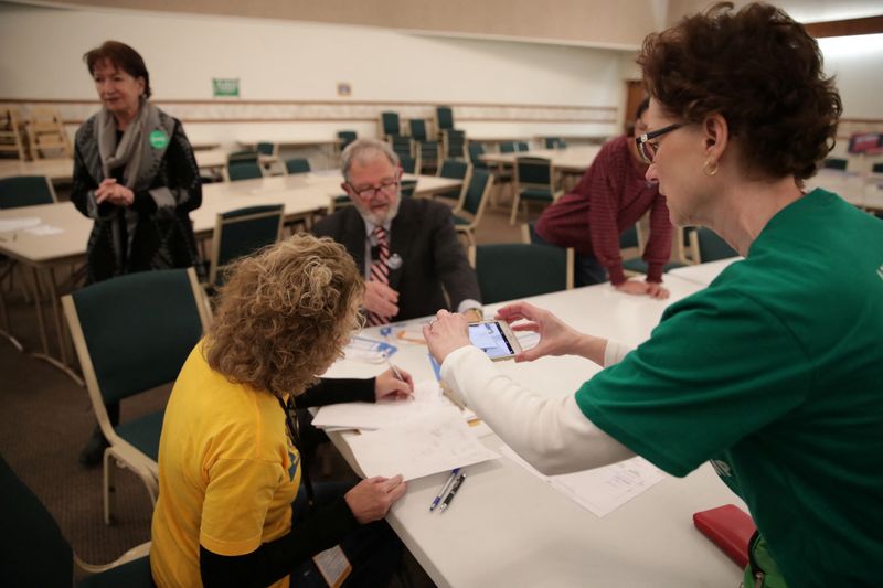 &copy; Reuters. FILE PHOTO: A precinct worker documents the process with her phone as Iowa Caucus precinct workers count  paper ballots after a Democratic presidential caucus at West Des Moines Christian Church in West Des Moines, Iowa, U.S., February 3, 2020. Picture ta