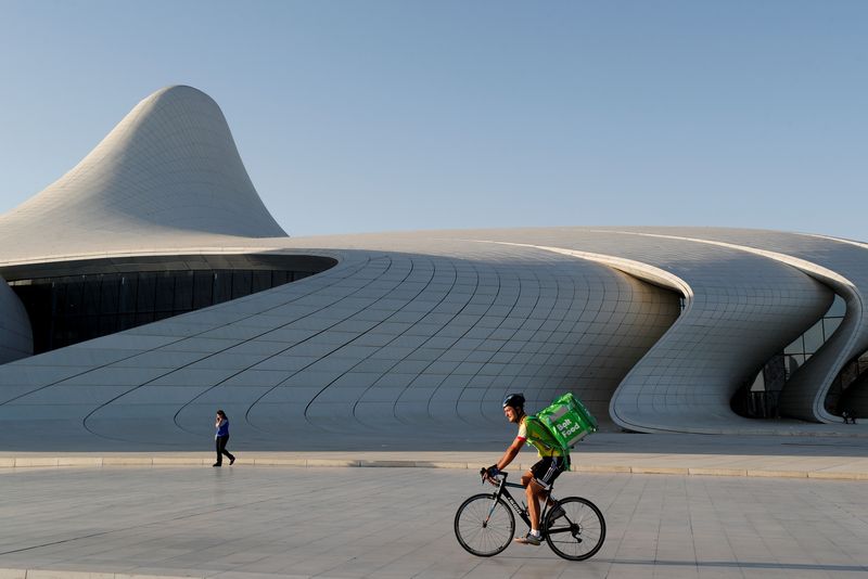 &copy; Reuters. FILE PHOTO: A Bolt Food delivery courier rides a bicycle outside the Heydar Aliyev Center in Baku, Azerbaijan June 18, 2021.  REUTERS/Valentyn Ogirenko/File Photo