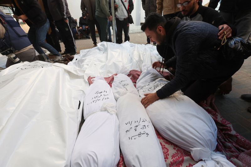 © Reuters. مشيعون بجوار جثامين لفلسطينين قتلوا في الغارات الإسرائيلية في مستشفى برفح في جنوب قطاع غزة يوم الثلاثاء. تصوير: إبراهيم أبو مصطفي - رويترز.