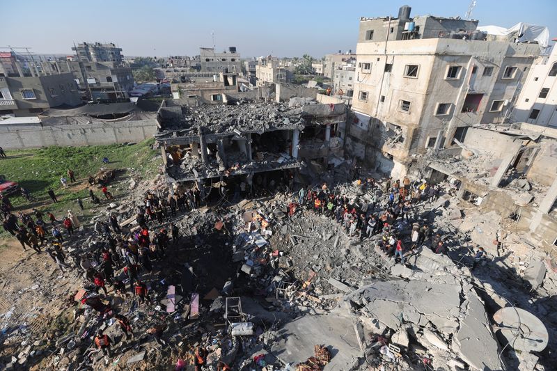 © Reuters. Varios palestinos se reúnen en el lugar de un ataque israelí contra una casa, en medio del actual conflicto entre Israel y el grupo islamista palestino Hamás, en Rafah, en el sur de la Franja de Gaza

Dic 19, 2023. REUTERS/Ibraheem Abu Mustafa