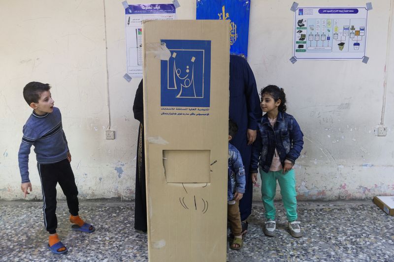 &copy; Reuters. Eleitores votam ao lado de crianças em eleições para os conselhos regionais do Iraque, em Bagdá
18/12/2023
REUTERS/Ahmed Saad
