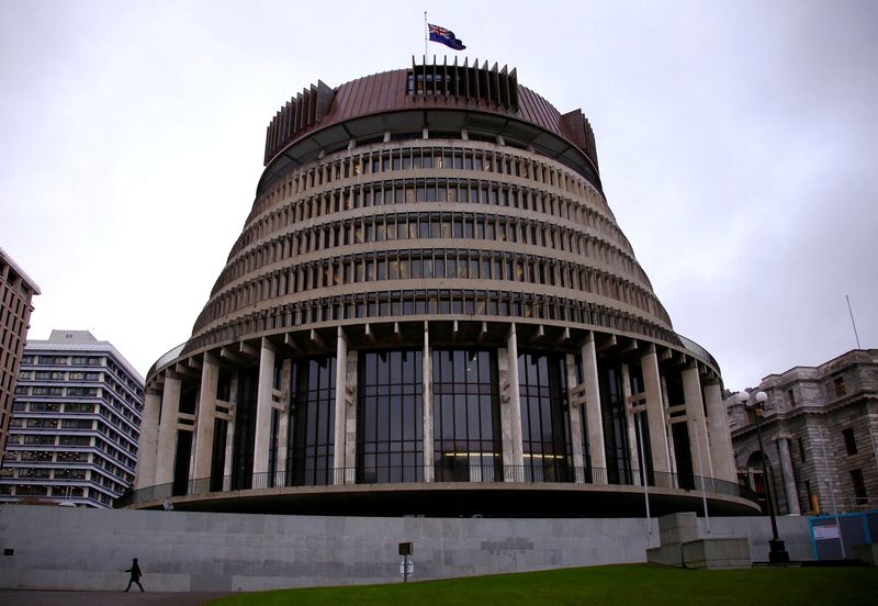 © Reuters. FILE PHOTO: A pedestrian walks past the New Zealand parliament building known as the Beehive in central Wellington, New Zealand, July 3, 2017. REUTERS/David Gray