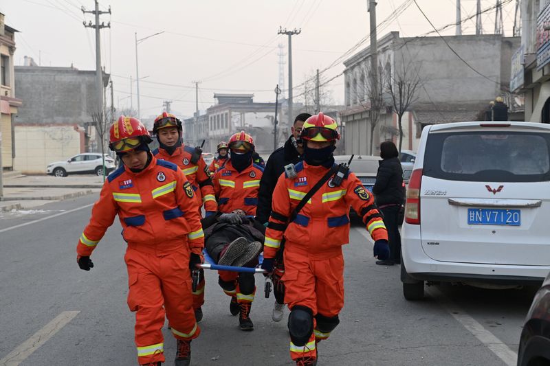 &copy; Reuters. Rescue workers carry an injured person on a stretcher at Dahejia town following the earthquake in Jishishan county, Gansu province, China December 19, 2023. cnsphoto via REUTERS  