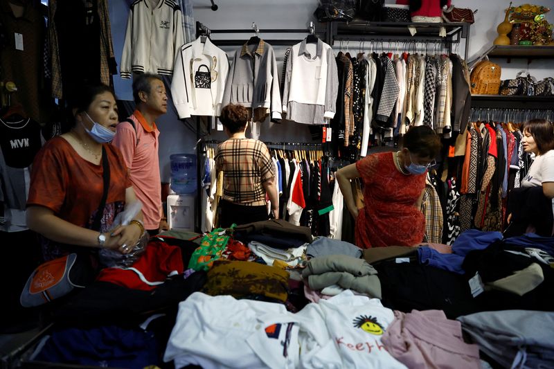 &copy; Reuters. 　中国の小売企業は価格に敏感な消費者を獲得しようと低価格戦略にシフトしており、足元のデフレ基調が経済に根付いてしまうリスクも生じている。写真は北京の卸売市場内の露店で衣料