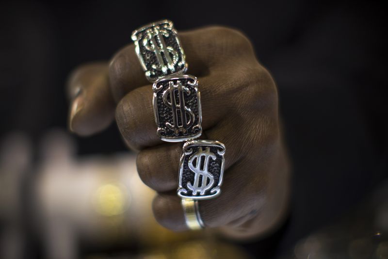 © Reuters. FILE PHOTO: A man wears U.S. dollar sign rings in a jewellery shop in Manhattan in New York City November 6, 2014. Picture taken November 6, 2014. REUTERS/Mike Segar 