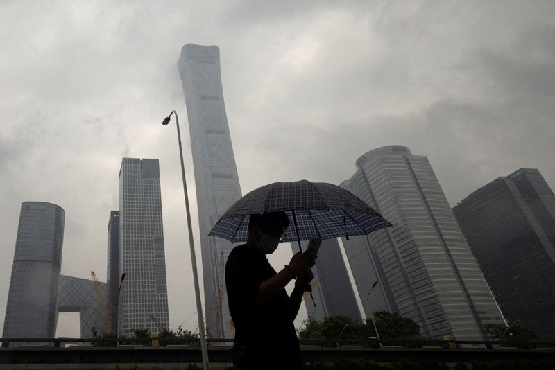 &copy; Reuters. FILE PHOTO: A man walks in the Central Business District on a rainy day, in Beijing, China, July 12, 2023. REUTERS/Thomas Peter/