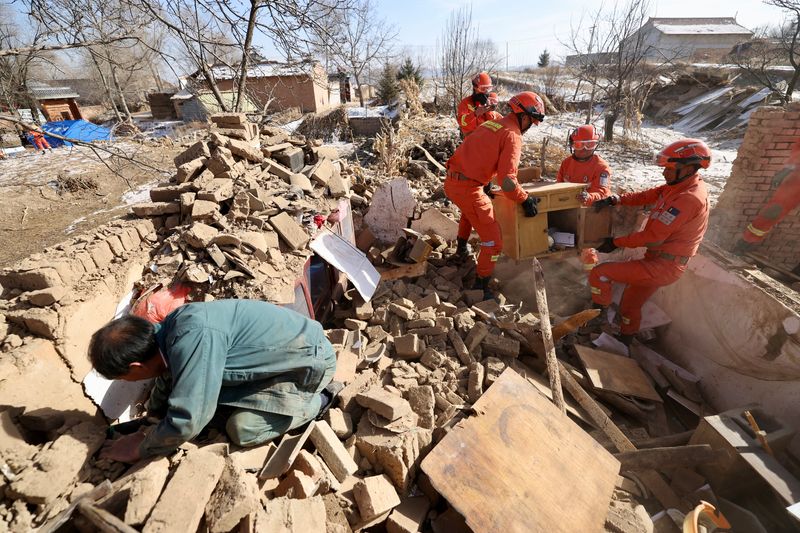 © Reuters. Rescue workers retrieve belongings from a damaged house at Shiyuan village following the earthquake in Jishishan county, Gansu province, China December 20, 2023.  China Daily via REUTERS