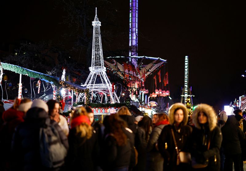 &copy; Reuters. Des personnes marchent devant une tour Eiffel illuminée lors d'une foire de Noël installée dans le Jardin des Tuileries à Paris, en France. /Photo prise le 18 décembre 2023/REUTERS/Sarah Meyssonnier