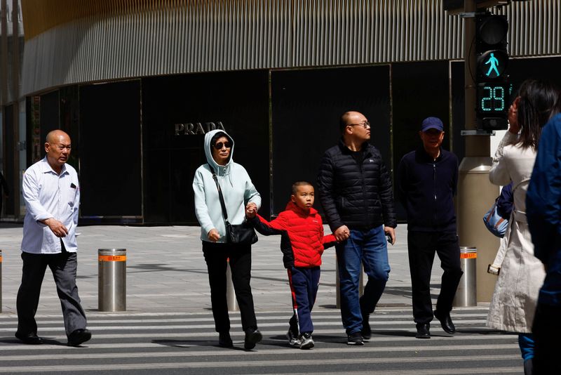 &copy; Reuters. FILE PHOTO: People walk on a street at a shopping area in Beijing, China April 11, 2023. REUTERS/Tingshu Wang/File photo