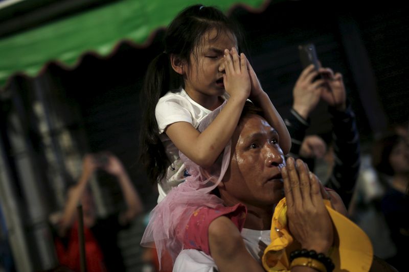&copy; Reuters. FILE PHOTO: A girl and her father pray to the Taoist goddess Mazu, during a nine-day procession in her honour, in Taichung, Taiwan April 8, 2016. Picture taken April 8. REUTERS/Tyrone Siu