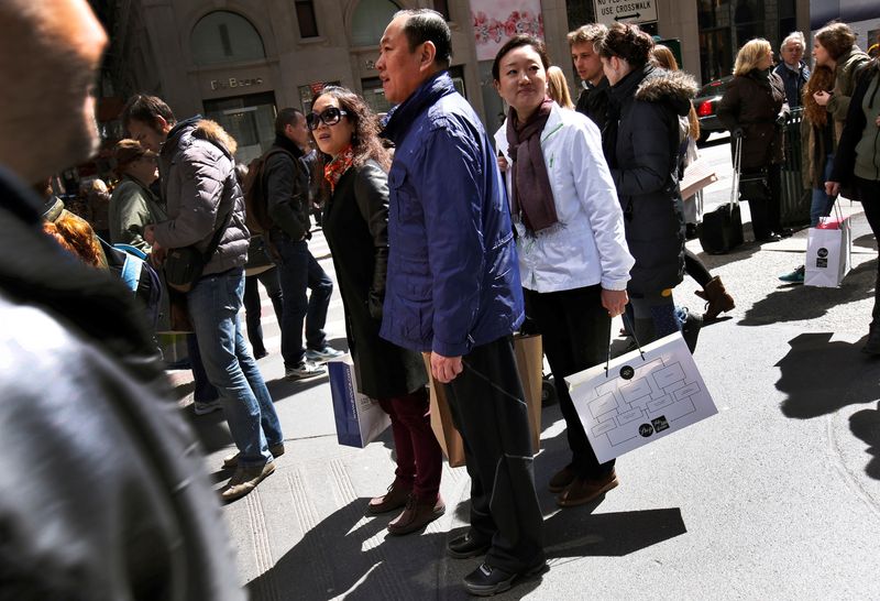 © Reuters. Chinese shoppers stand with shopping bags on a sidewalk along 5th Avenue in New York City, April 4, 2013. REUTERS/Mike Segar/File photo
