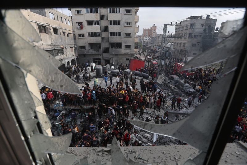 &copy; Reuters. Palestinos reunidos en el lugar de un ataque israelí contra una casa, en medio del conflicto en curso entre Israel y el grupo islamista palestino Hamás, en Ráfah, en el sur de la Franja de Gaza, 20 de diciembre de 2023. REUTERS/Ibraheem Abu Mustafa