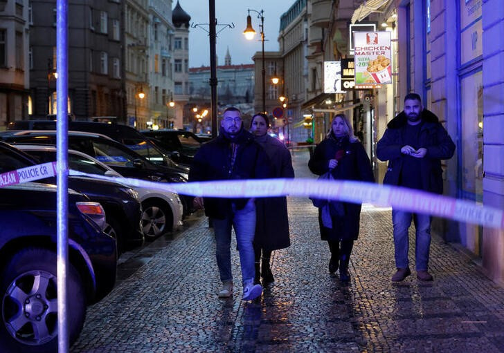 © Reuters. Unos transeúntes caminan cerca del parea acordonada por la policía checa tras un tiroteo en el que murieron al menos 15 personas en una universidad de Praga. Diciembre 21, 2023. REUTERS/David W Cerny