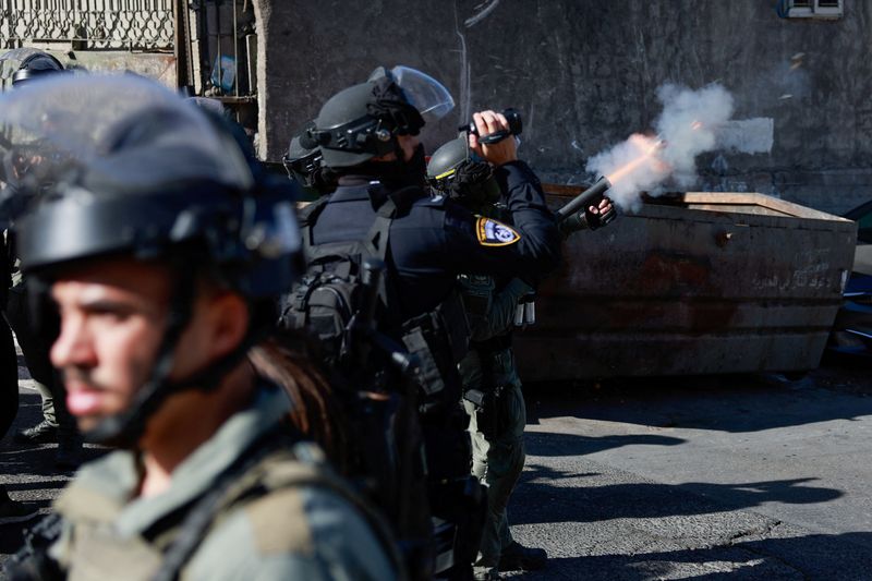 &copy; Reuters. Un agente della polizia di frontiera israeliana spara del gas per il controllo della folla, mentre i fedeli musulmani palestinesi cercano di tenere la preghiera del venerdì in una strada fuori dalla Città Vecchia di Gerusalemme, mentre continua il confl