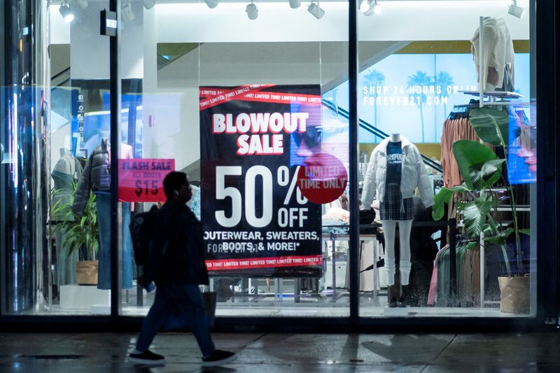 &copy; Reuters. FILE PHOTO: A woman passes by a local store with discounts during the holiday season in New York City, U.S., December 10, 2023. REUTERS/Eduardo Munoz