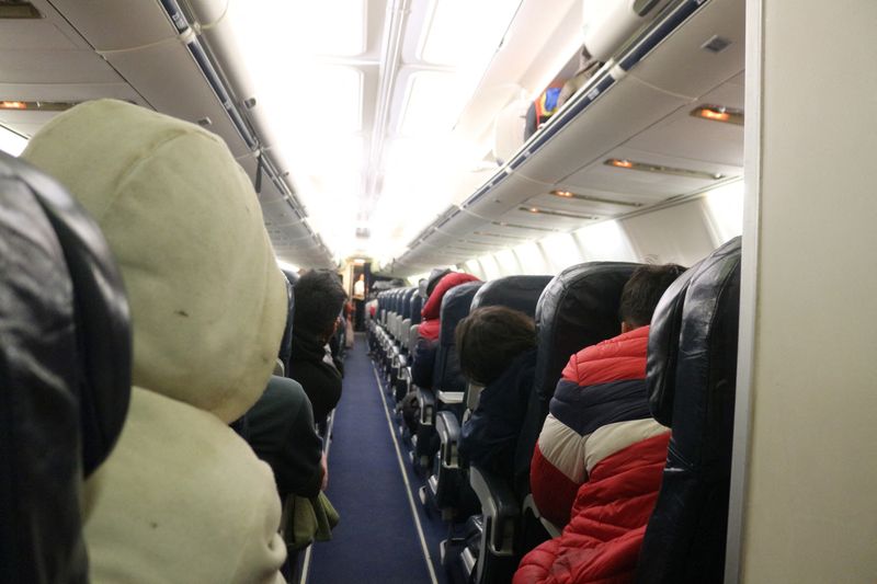 © Reuters. Migrants sit on a plane bound for southern Mexico as part of a repatriation flight to their countries, at the Piedras Negras International Airport, in Piedras Negras, Coahuila state, Mexico, December 22, 2023. Government of the State of Coahuila/Handout via REUTERS 