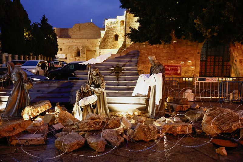 &copy; Reuters. Figuras religiosas em meio a escombros e cercadas por arame farpado, como forma de apoio a Gaza, do lado de fora da Igreja da Natividade, na Praça da Manjedoura, em Belém, na Cisjordânia ocupada por Israel.
23/12/2023
REUTERS/Clodagh Kilcoyne