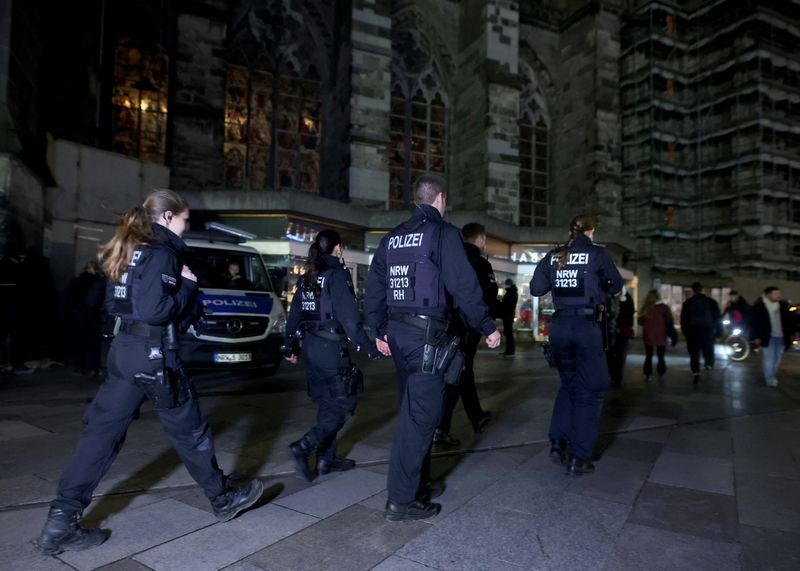 &copy; Reuters. قوات من الشرطة الألمانية تسير أمام كاتدرائية كولونيا بألمانيا يوم السبت. تصوير: تيلو شمولجين - رويترز.
