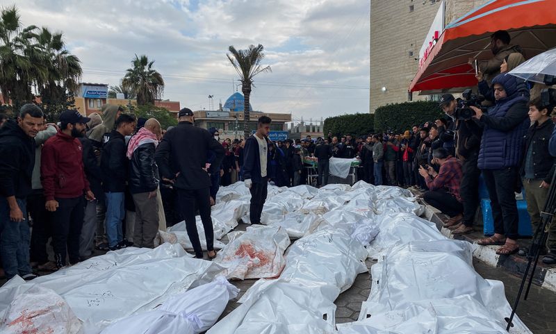 © Reuters. مشيعون بجوار جثامين الفلسطينيين الذين قتلوا في الغارات الإسرائيلية في مستشفى بوسط قطاع غزة يوم الاثنين. تصوير: دعاء روقة - رويترز.

