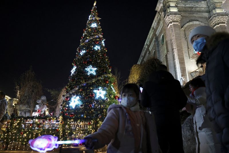 &copy; Reuters. Criança segura um brinquedo perto de uma árvore de Natal do lado de fora da Catedral do Sul, uma igreja católica em Xuanwumen, na véspera de Natal em Pequim
24/12/2023
REUTERS/Florence Lo