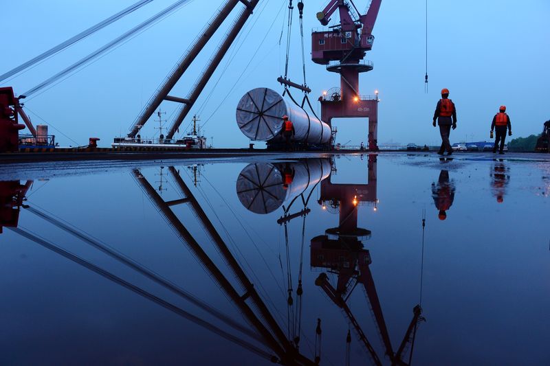 &copy; Reuters. Workers are seen near a crane lifting offshore wind energy equipment by China Construction Industrial and Energy Engineering Group Co at a port in Nanjing, Jiangsu province, China April 23, 2019./file photo