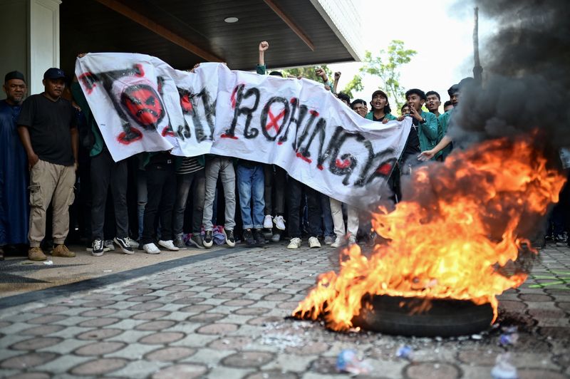 &copy; Reuters. متظاهرون إندونيسيون يحرقون إطارًا خلال احتجاج على ترحيل لاجئي الروهينجا في باندا أتشيه بإندونيسيا يوم الأربعاء. تصوير: ريسكا منورة - رويترز