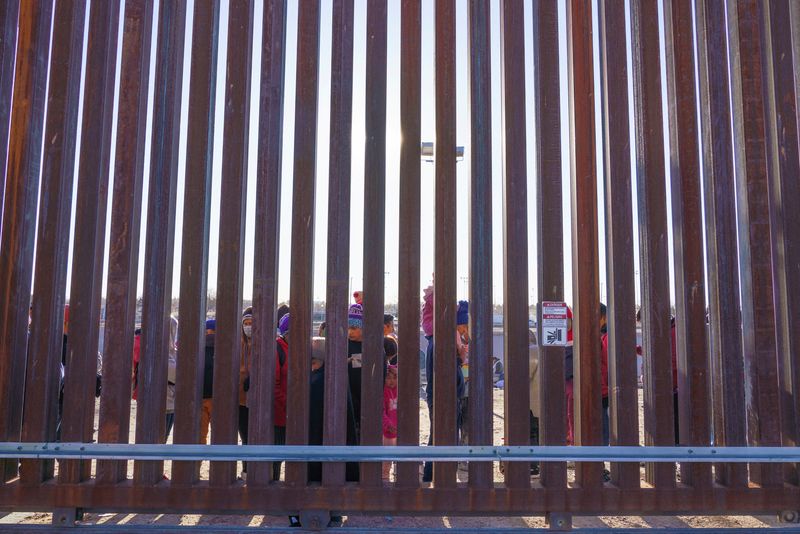 &copy; Reuters. FILE PHOTO: Migrants from Nicaragua and Ecuador stand by a door on the border wall waiting to be picked up by United States Border Patrol in El Paso, Texas, U.S., January 4, 2023. REUTERS/Paul Ratje/File Photo