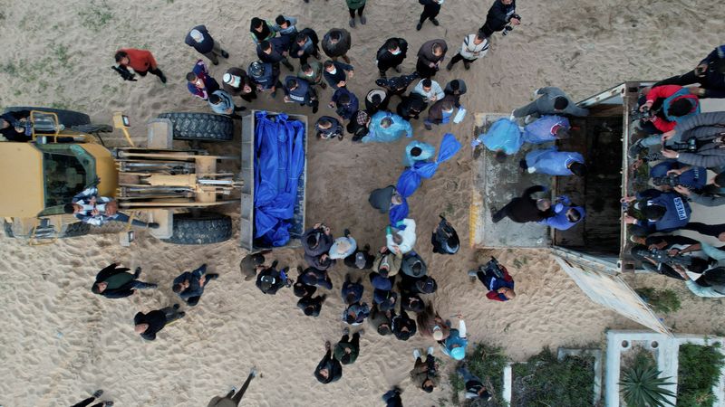 © Reuters. People prepare to bury Palestinians, who were killed by Israeli strikes and fire, after their bodies were released by Israel, amid the ongoing conflict between Israel and the Palestinian Islamist group Hamas, at a mass grave in Rafah, in the southern Gaza Strip December 26, 2023. REUTERS/Shadi Tabatibi     