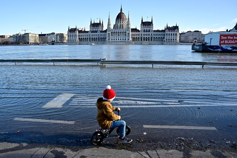 &copy; Reuters. Un niño anda en bicicleta en un muelle inundado por el río Danubio en Budapest, Hungría, el 27 de diciembre de 2023. REUTERS/Marton Monus