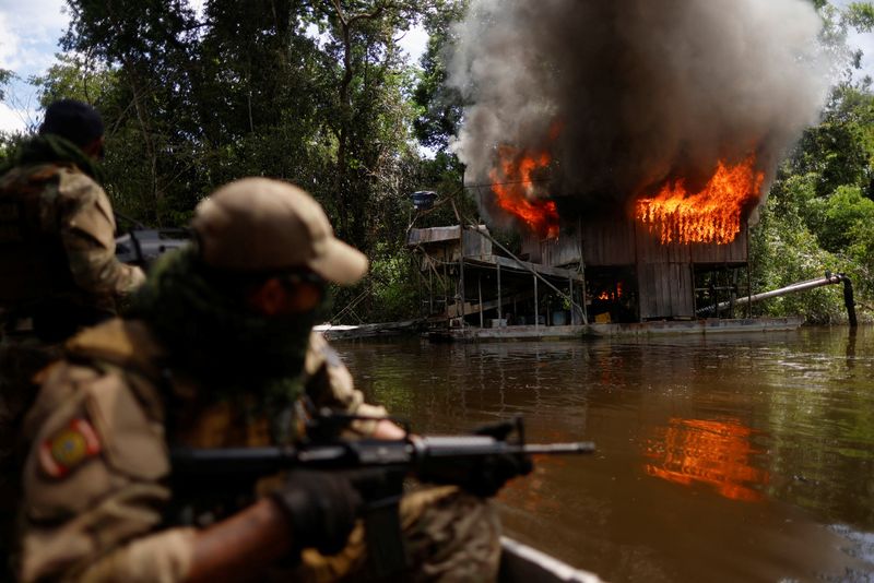 © Reuters. An illegal gold dredge burns in Paruari river during an operation against illegal gold mining at the Urupadi National Forest Park in the Amazon rainforest, conducted by agents of the Chico Mendes environmental agency ICMBio with support of the Federal Police, the Federal Highway Police, Brazilian Intelligence Agency (ABIN) agents and Brazilian Public-Safety National Force officers, in the municipality of Maues, Amazonas state, Brazil June 1, 2023. REUTERS/Adriano Machado/File Photo