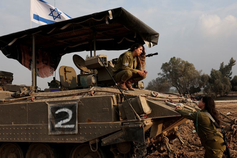 © Reuters. An Israeli soldier crouches on an armoured personnel carrier (APC), amid the ongoing conflict between Israel and the Palestinian Islamist group Hamas, near the Israel-Gaza border, in southern Israel, December 28, 2023. REUTERS/Violeta Santos Moura 